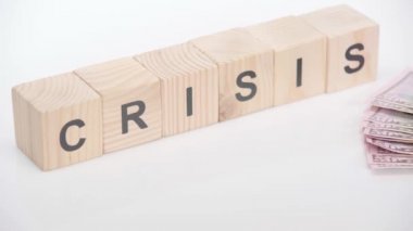 Küplerin yanında dolar banknotları ve beyaz arkaplanda kriz harfleri