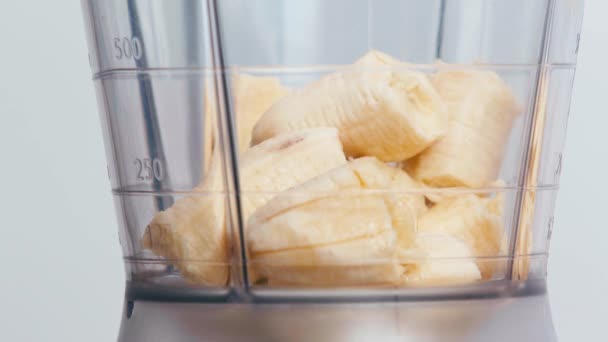 Sluiten Van Melk Gieten Blender Met Bananen — Stockvideo