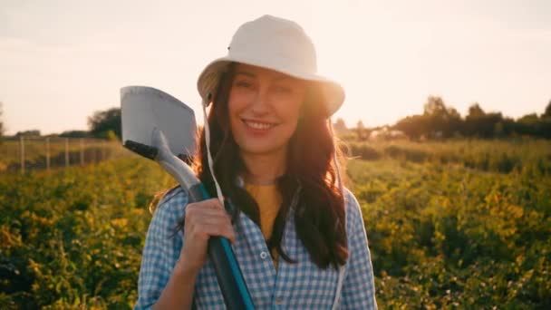 Şapkalı Kadın Elinde Kürekle Tarlada Kameraya Bakıyor — Stok video