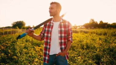 Çiftçinin cebinde ve tarlada küreği var. 