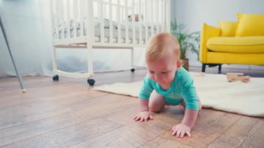 Bebek oturma odasında yerde sürünüyor. 