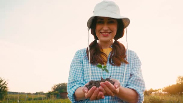 Брюнетка Женщина Шляпе Холдинг Земли Небольшим Растением Руках — стоковое видео