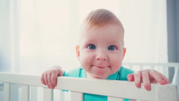 Vreugdevolle Baby Jongen Staan Baby Wieg Kijken Naar Camera — Stockvideo