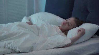 Genç kadın yatakta yatıyor ve uyumakta zorlanıyor. 