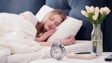 Alarm saatini kapatan uyuyan kadının seçici odağı