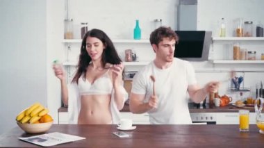 Kahve ve portakal rengi masalarda dans eden seksi çift. 