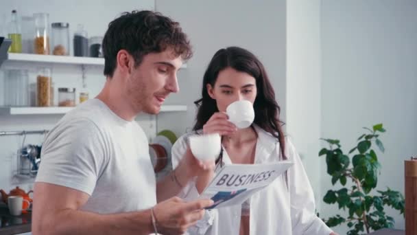 Man Drinking Coffee Reading News Sexy Girlfriend Kitchen — Stock Video