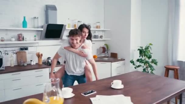 Femme Piggybackking Sur Petit Ami Près Café Smartphone Sur Table — Video