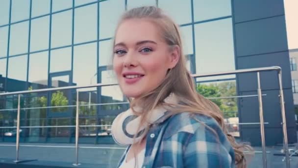 Junge Frau Mit Kabellosen Kopfhörern Blickt Auf Kamera Der Nähe — Stockvideo