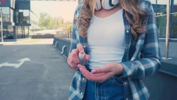 Περικοπή Άποψη Της Γυναίκας Ασύρματα Ακουστικά Εφαρμογή Απολυμαντικό Στα Χέρια — Αρχείο Βίντεο