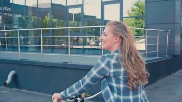 Νεαρή Γυναίκα Ιππασία Ποδήλατο Κοντά Στο Σύγχρονο Κτίριο Έξω — Αρχείο Βίντεο