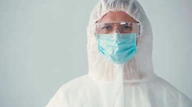 Gri üzerinde test tüpü tutan tehlikeli madde kostümlü bilim adamının odak noktası.
