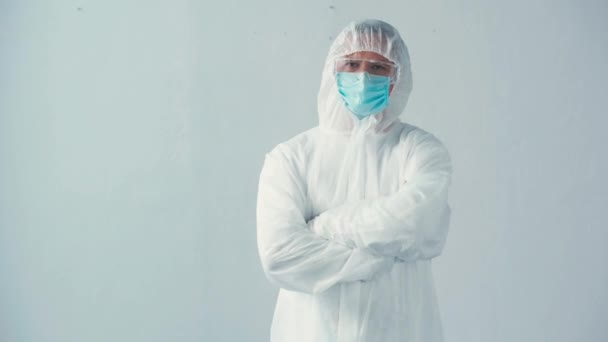ハズマットスーツの科学者と灰色の腕を組んで立っている医療用マスク — ストック動画