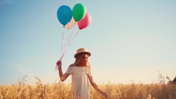 Kind Weißem Kleid Und Strohhut Läuft Mit Luftballons Weizenfeld — Stockvideo