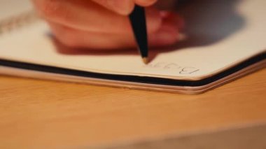 Spiral defter üzerine yazan adamı odakla