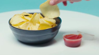 Seçici odak noktası, çipleri ketçapa batıran adam.