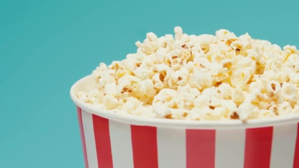 Berputar Popcorn Dalam Ember Kertas Diisolasi Pada Latar Belakang Biru — Stok Video