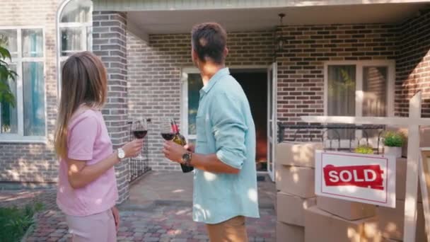 Homem Segurando Garrafa Vinho Enquanto Clinking Copos Com Esposa Perto — Vídeo de Stock