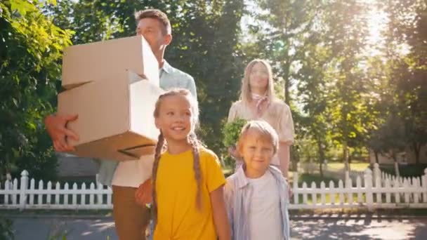 Eltern Mit Kisten Und Pflanzen Beim Spaziergang Mit Kindern Umzugskonzept — Stockvideo