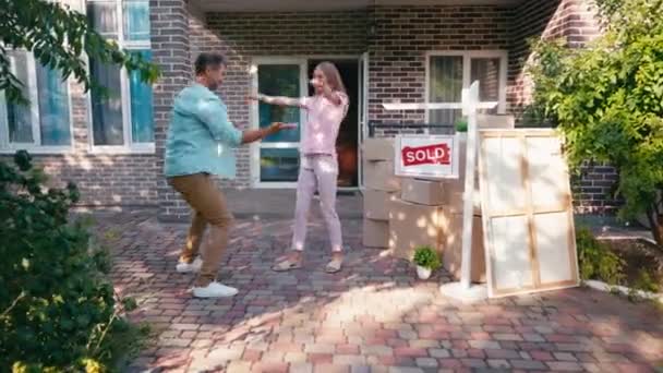 Jubelpaar Gibt High Five Und Springt Nahe Neuem Haus Und — Stockvideo