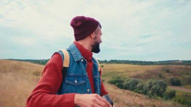 Turistler etrafa bakınıyor ve tepelerde klasik kamerayla selfie çekiyorlar.