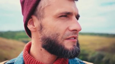 Gezgin portresi kameraya bakıyor ve uzaklaşıyor.