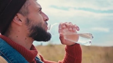 Şişeden su içen gezginin yan görüntüsü