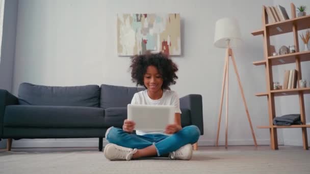 African American Κορίτσι Σταυρωμένα Πόδια Χρησιμοποιώντας Ψηφιακή Ταμπλέτα Στο Σπίτι — Αρχείο Βίντεο