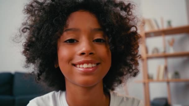 非洲裔美国女孩笑着看着家里的相机的选择性聚焦 — 图库视频影像