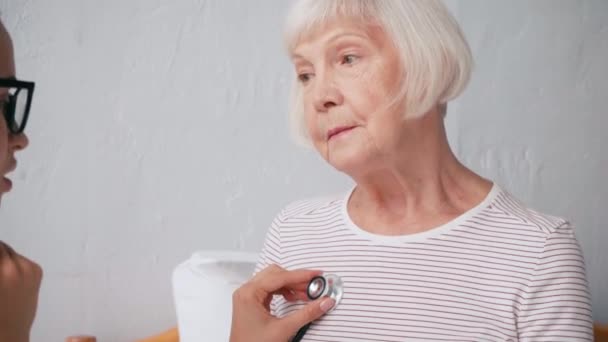 高齢者を聴診器で診察する若い婦人科医は — ストック動画