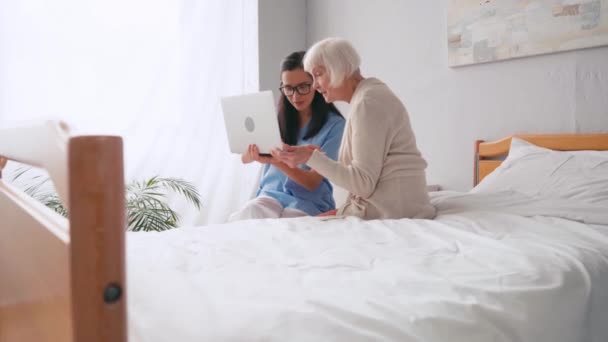 Femme Âgée Pointant Doigt Tout Utilisant Ordinateur Portable Avec Infirmière — Video