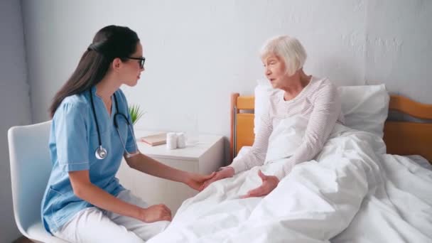 老年病学和老年妇女手牵手 在诊所里交谈 — 图库视频影像