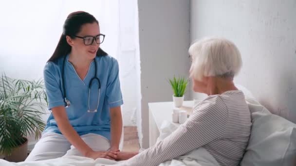 Jonge Positieve Geriater Praten Met Oudere Vrouw Het Ziekenhuis — Stockvideo