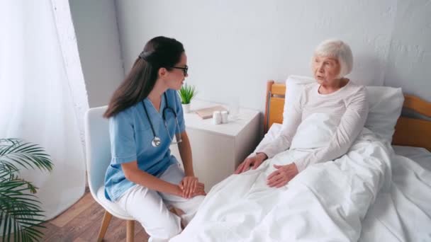 Stárnoucí Žena Gestikuluje Zatímco Leží Posteli Mluví Lékařem — Stock video