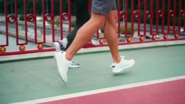 Köprüde koşu yolunda koşan spor ayakkabılı çift görüntüsü