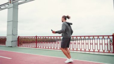 Sporcu halatı köprüde atlarken arka planda doğa, yavaş çekim