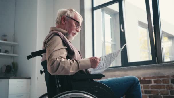 Seitenansicht Eines Älteren Mannes Rollstuhl Der Hause Zeitung Fenster Liest — Stockvideo