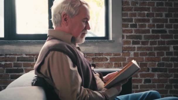 Seitenansicht Des Positiven Älteren Mannes Der Buch Liest Und Lacht — Stockvideo