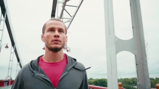 Spor Kıyafetlerine Odaklanmış Bir Adam Köprüde Koşuyor Arka Planda Bulutlu — Stok video