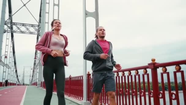 Müdes Läuferpaar Rennt Und Stoppt Mit Atemnot Auf Brücke — Stockvideo