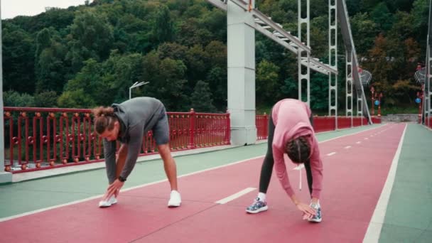 Mann Und Frau Sportbekleidung Strecken Sich Auf Brücke Mit Der — Stockvideo