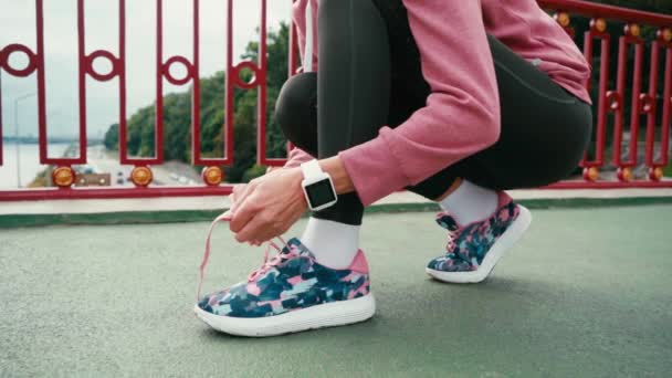 Vista Recortada Deportista Con Smartwatch Atando Cordones Zapatilla Puente — Vídeos de Stock