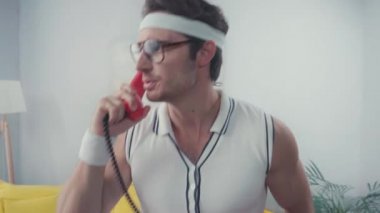 Ev telefonunda konuşan enerjik sporcunun portresi.