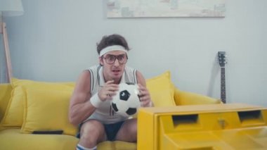 Evdeki kanepede televizyon izlerken gergin futbol izleyicileri sinirleniyorlar.