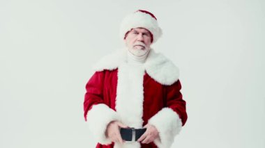 Katı Noel Baba konuşuyor ve beyaz kameraya parmak sallıyor.