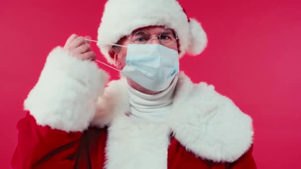 Święty Mikołaj Zdejmuje Maskę Medyczną Uśmiecha Się Kamery Odizolowanej Czerwono — Wideo stockowe