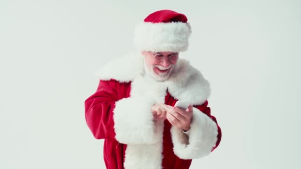 Weihnachtsmann Plaudert Auf Smartphone Und Berührt Brille Isoliert Auf Weiß — Stockvideo