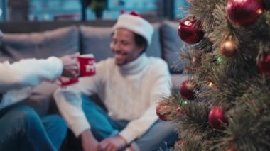 Afrika kökenli Amerikalı bir çiftin yanındaki Noel ağacının fincanları bulanık.