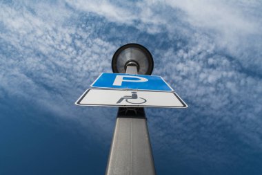 Özürlü park yeri, bulutlar ve arka planda mavi gökyüzü