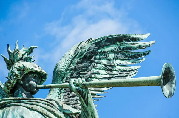 Estátua de anjo tocando trompete na frente do céu azul Fotos De Bancos De Imagens